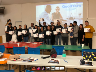 GoodYarn Filipino cohort with their children. Participants are standing at the front of a classroom, holding thei completion certificates and smiling at the camera.