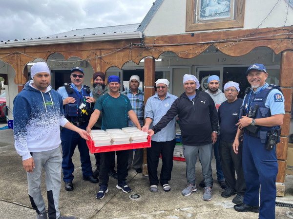 Members of NZ Police and the Sikh community providing food.
